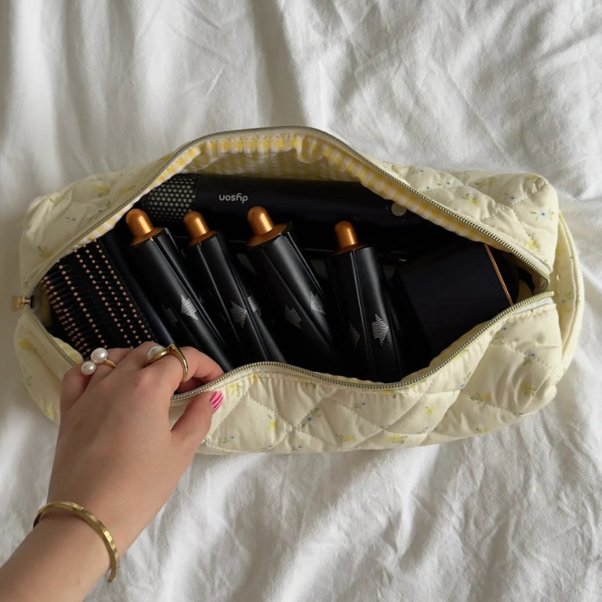Set of hair rollers in a beige carrying case on a white background
