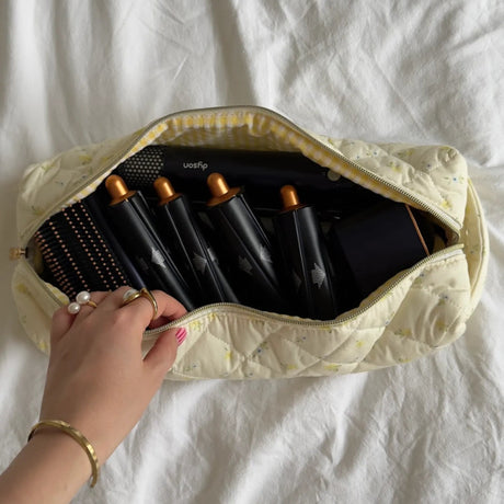 Set of hair rollers in a beige carrying case on a white background