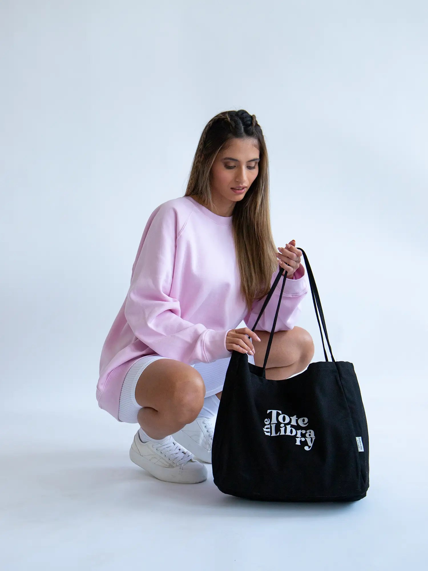 Latin Model wearing the black coastal carryall functional tote bag from The Tote Libray